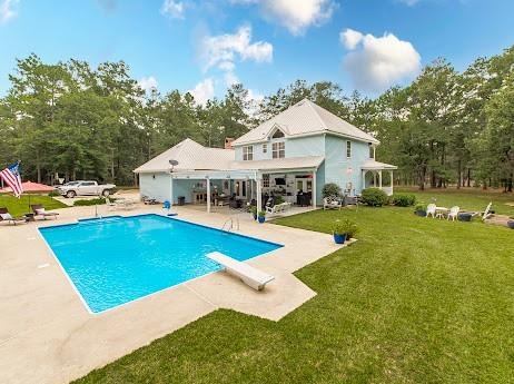 rear view of property featuring a patio and a yard