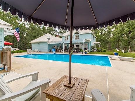 view of pool featuring a patio and a diving board