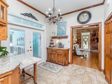 kitchen featuring plenty of natural light, french doors, light wood-type flooring, and ornamental molding