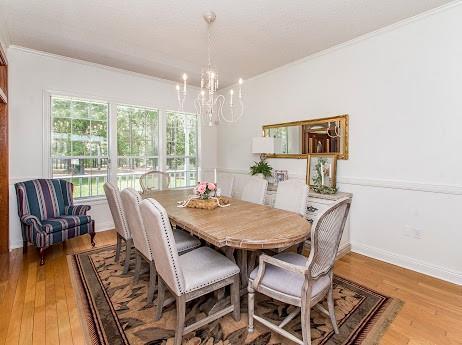 dining room with ornamental molding, hardwood / wood-style floors, and a chandelier