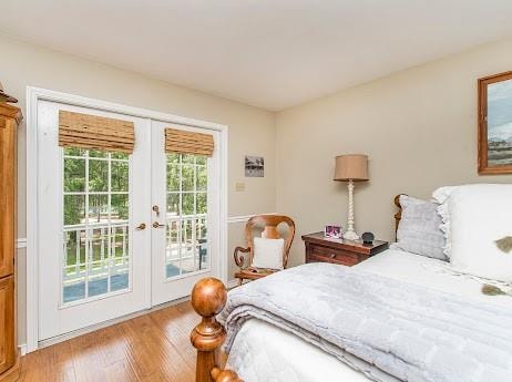 bedroom with light hardwood / wood-style floors, access to outside, and french doors