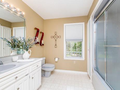 full bathroom featuring tile patterned flooring, toilet, vanity, and enclosed tub / shower combo