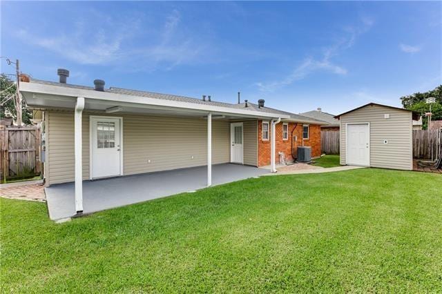 1112 Michael St, Marrero, LA 70072 - rear view of house with central AC, a storage unit, a patio, and a lawn