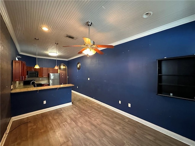 kitchen with crown molding, visible vents, freestanding refrigerator, wood finished floors, and a peninsula