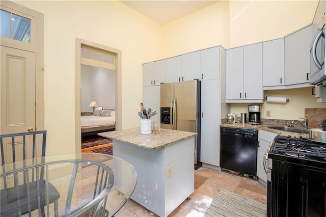 kitchen featuring light tile patterned flooring, a center island, appliances with stainless steel finishes, and sink