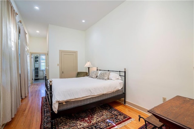 bedroom with a high ceiling and light wood-type flooring