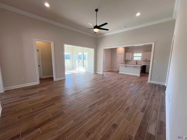 unfurnished living room with dark hardwood / wood-style flooring, crown molding, ceiling fan, and plenty of natural light