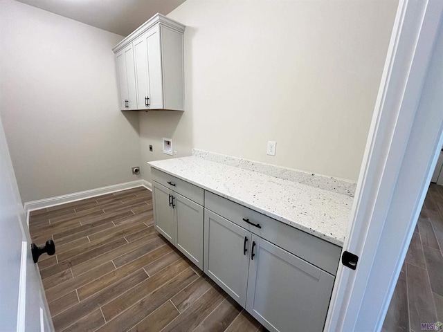 washroom with hookup for a washing machine, electric dryer hookup, cabinets, and dark hardwood / wood-style floors