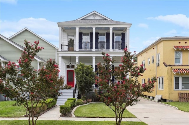 view of front of property featuring a balcony and a front yard