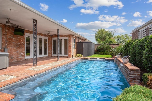 view of swimming pool featuring ceiling fan, pool water feature, and a patio area