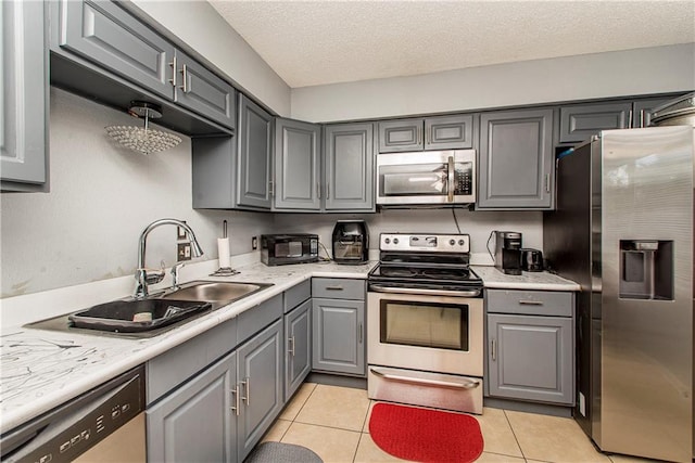 kitchen featuring gray cabinets, light tile patterned flooring, and stainless steel appliances