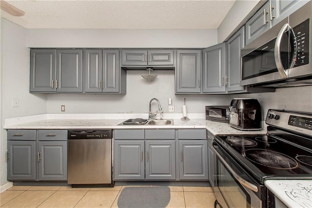 kitchen featuring gray cabinets, appliances with stainless steel finishes, and light tile patterned floors