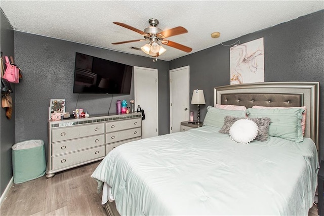 bedroom featuring ceiling fan, a textured ceiling, and hardwood / wood-style flooring