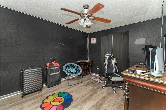 office featuring a textured ceiling, ceiling fan, and light wood-type flooring