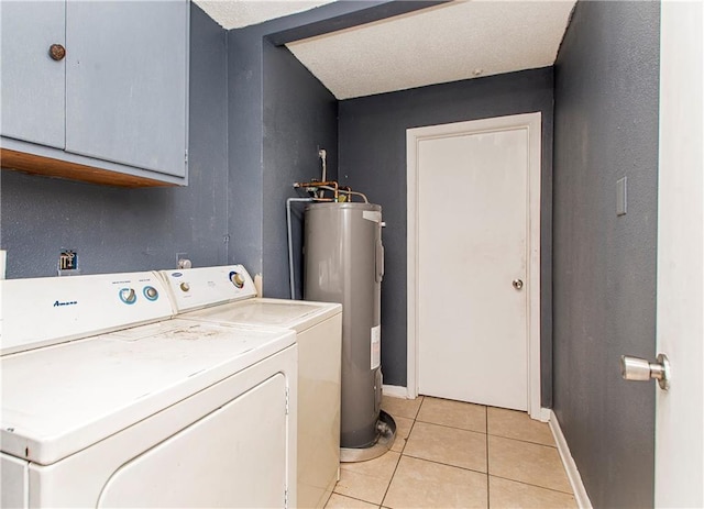 clothes washing area with water heater, cabinets, light tile patterned floors, and washing machine and clothes dryer