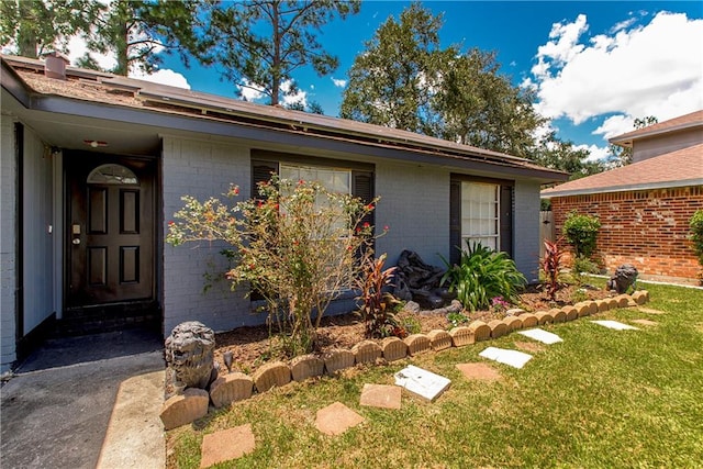 doorway to property with a lawn