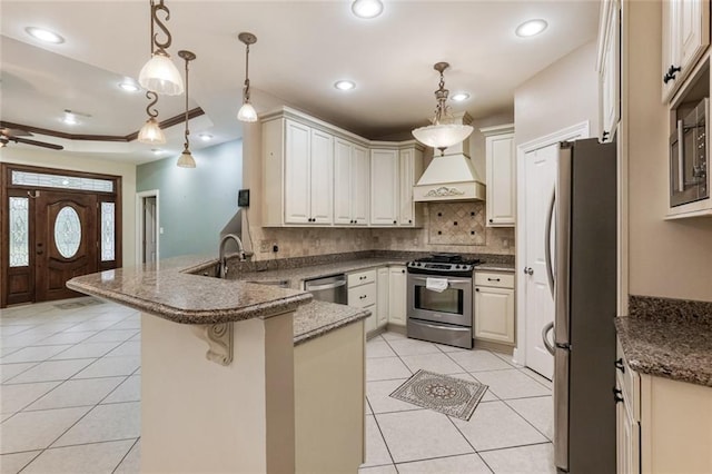 kitchen featuring pendant lighting, sink, a breakfast bar, appliances with stainless steel finishes, and kitchen peninsula