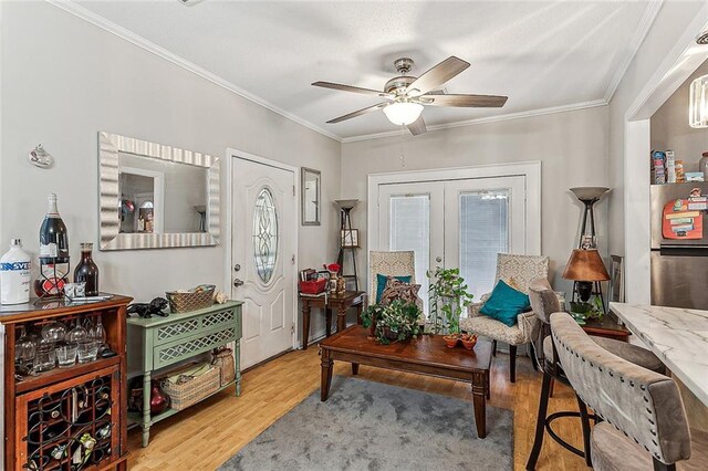 sitting room with crown molding, french doors, ceiling fan, and light hardwood / wood-style floors