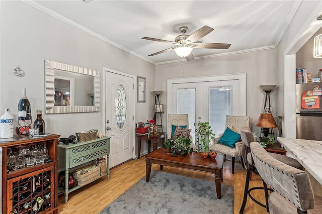 living area featuring ornamental molding, ceiling fan, french doors, and wood finished floors