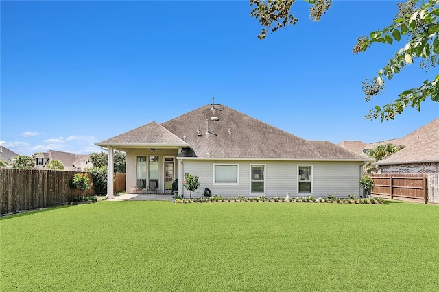 rear view of property featuring a patio and a yard