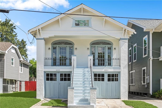 view of front facade with a garage, covered porch, and central air condition unit