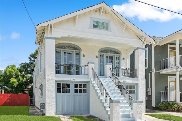 view of front of property with covered porch, a balcony, and a garage