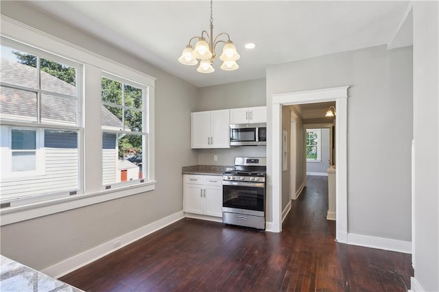 kitchen featuring pendant lighting, appliances with stainless steel finishes, dark hardwood / wood-style floors, and white cabinets