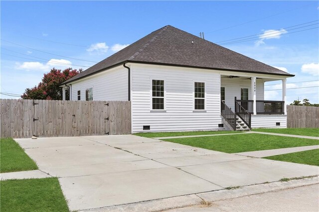 view of front of house with ceiling fan and a front yard