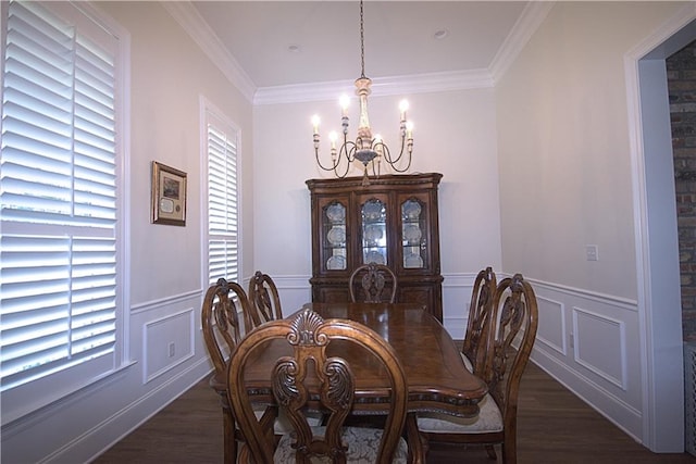 dining area featuring dark hardwood / wood-style floors, a healthy amount of sunlight, ornamental molding, and an inviting chandelier