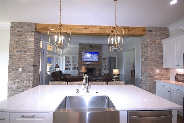 kitchen featuring pendant lighting, brick wall, and a fireplace