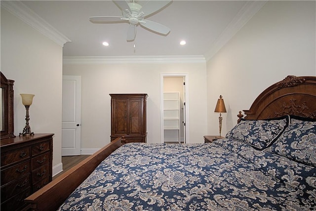 bedroom featuring ornamental molding, a spacious closet, ceiling fan, and hardwood / wood-style flooring