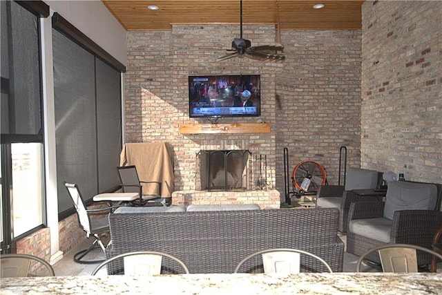 living room with brick wall, ceiling fan, and a brick fireplace