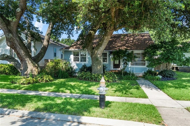 view of property hidden behind natural elements featuring a front yard