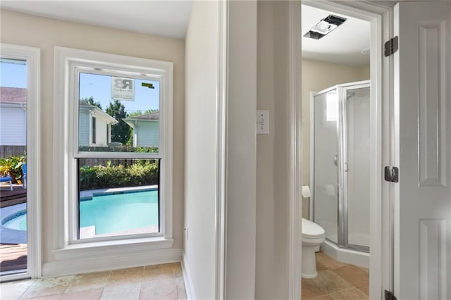 bathroom with a shower with shower door, toilet, and tile patterned floors