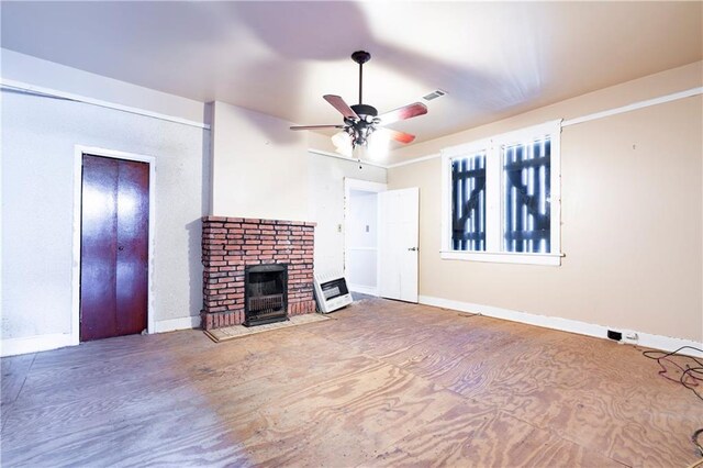 unfurnished living room with a brick fireplace and ceiling fan