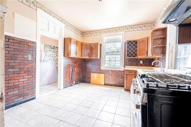 kitchen with light tile patterned flooring, custom exhaust hood, and gas range oven