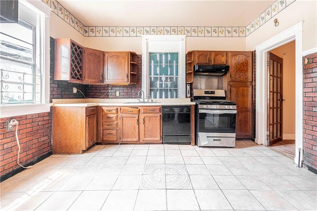 kitchen featuring sink, black dishwasher, brick wall, and stainless steel gas range