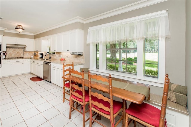 dining room featuring sink, crown molding, and light tile patterned floors