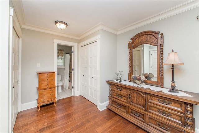 corridor with hardwood / wood-style flooring and ornamental molding