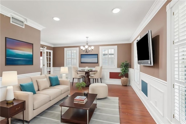 living room with ornamental molding, hardwood / wood-style flooring, and a chandelier