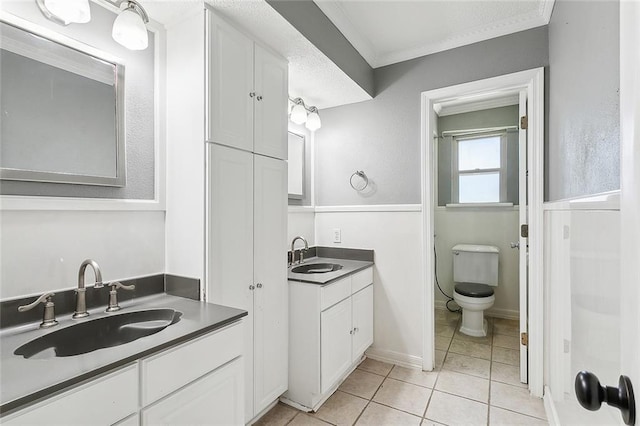 bathroom featuring ornamental molding, dual vanity, tile patterned flooring, and toilet