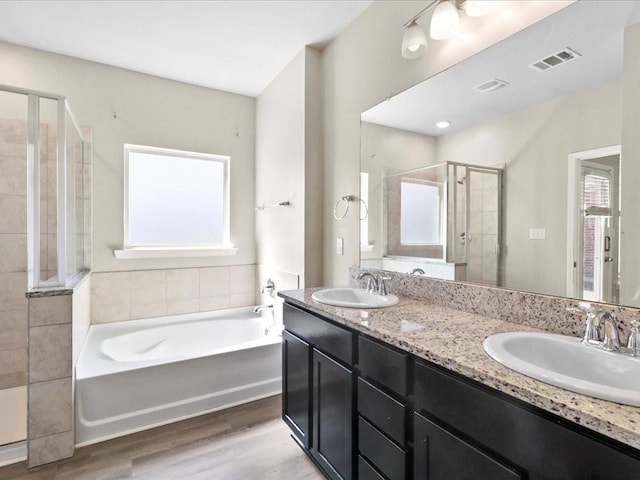 bathroom featuring hardwood / wood-style flooring, vanity, a healthy amount of sunlight, and independent shower and bath