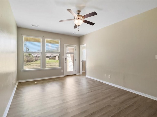 unfurnished room with dark hardwood / wood-style flooring and ceiling fan