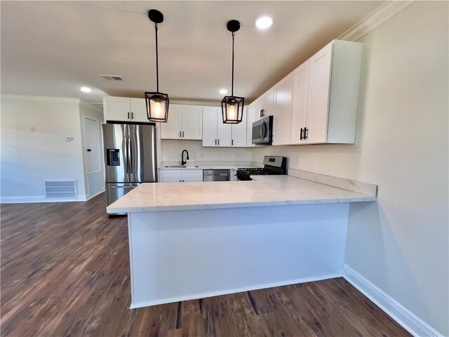 kitchen featuring stainless steel appliances, white cabinets, pendant lighting, kitchen peninsula, and dark wood-type flooring