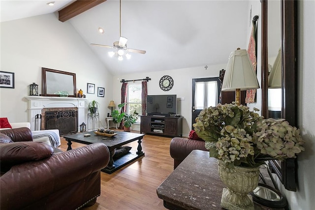 living room featuring beamed ceiling, light hardwood / wood-style flooring, ceiling fan, and high vaulted ceiling