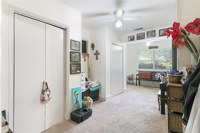 interior space featuring crown molding, light carpet, and ceiling fan