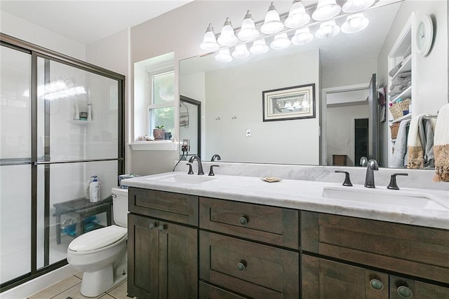 bathroom with tile patterned floors, double vanity, walk in shower, and toilet