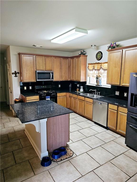 669 Lake Iberville Ct, Ponchatoula, LA 70454 - kitchen featuring appliances with stainless steel finishes, a sink, light tile patterned flooring, and backsplash