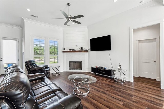 living room with dark hardwood / wood-style floors, ornamental molding, a high end fireplace, and ceiling fan