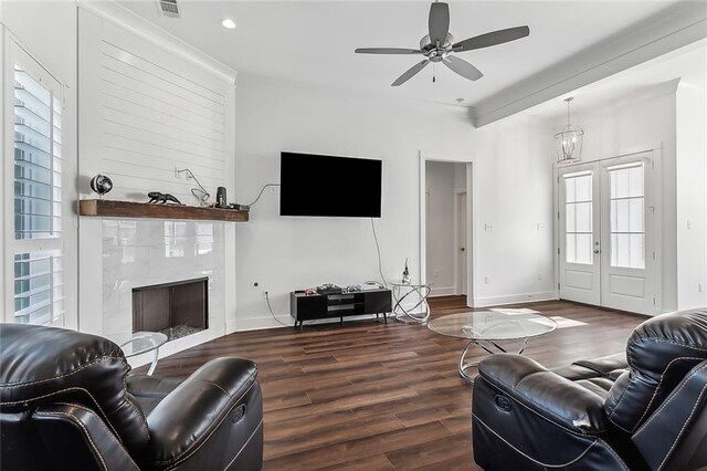 living room with a tiled fireplace, hardwood / wood-style floors, and ceiling fan